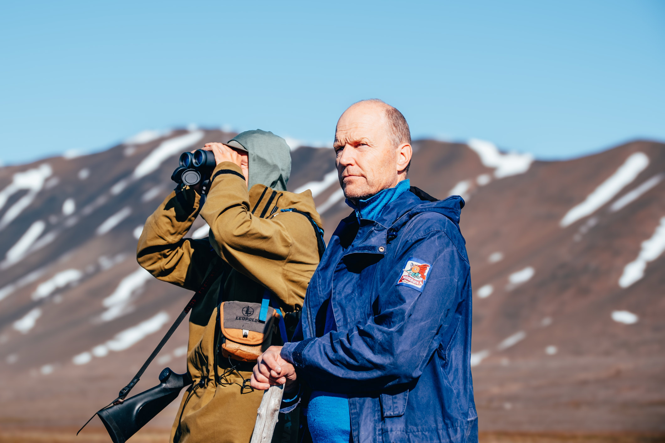 Two men looking out from mountain range in svalabrd