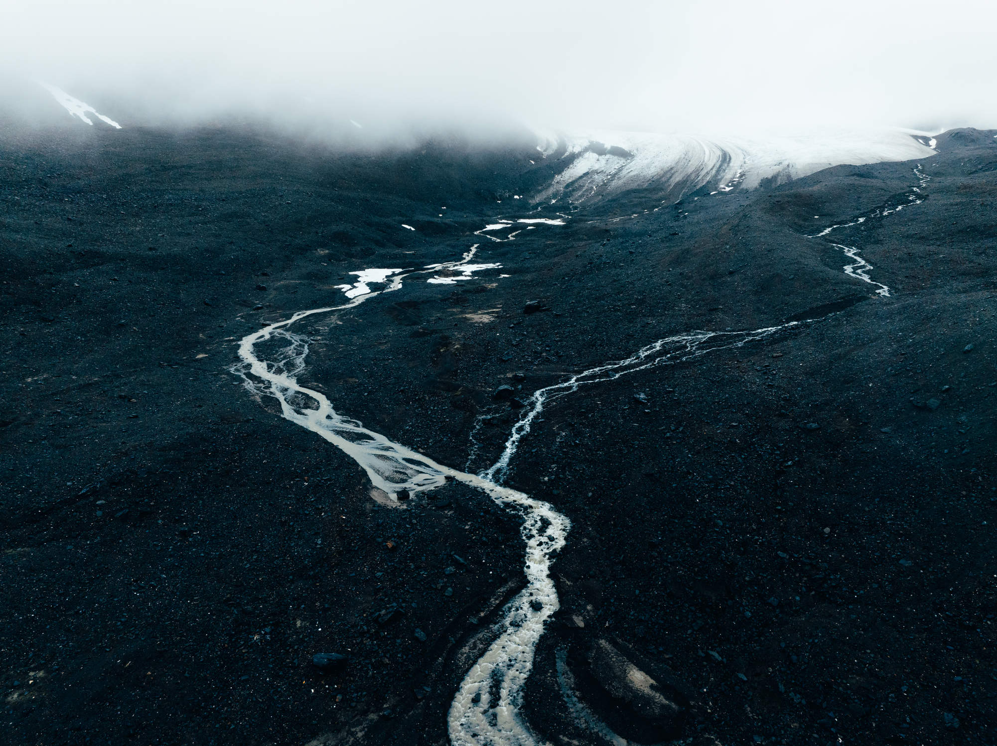 Dramatic dark landscape with river leading to glacier