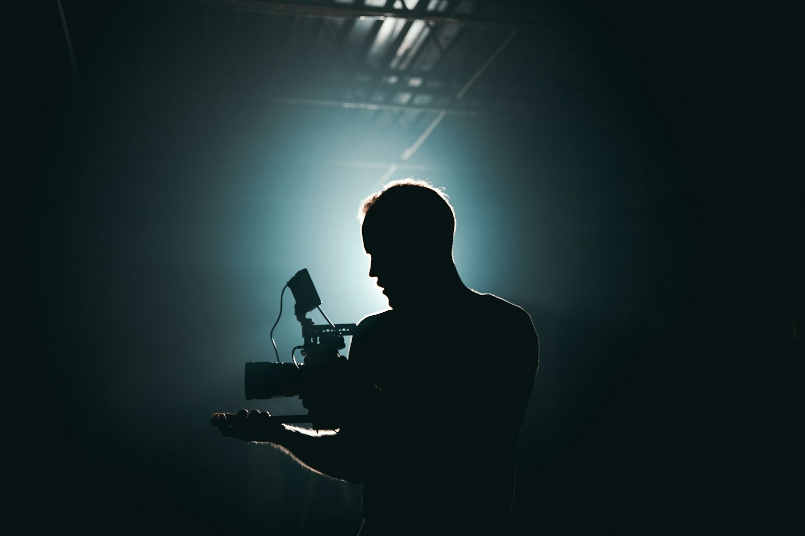 silhouette photography of man holding camera