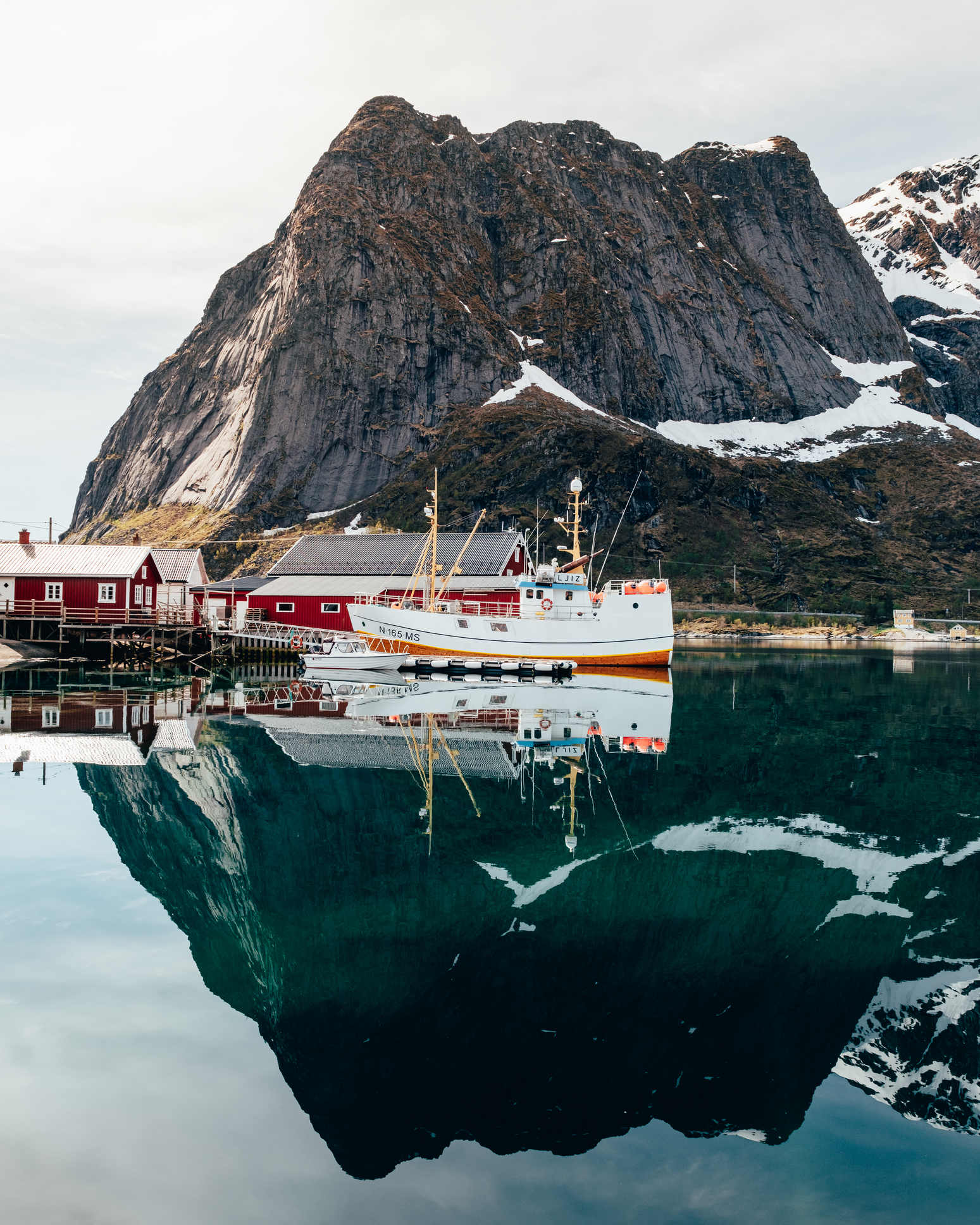 Reflections of a mountain and fishing boat in Lofoten