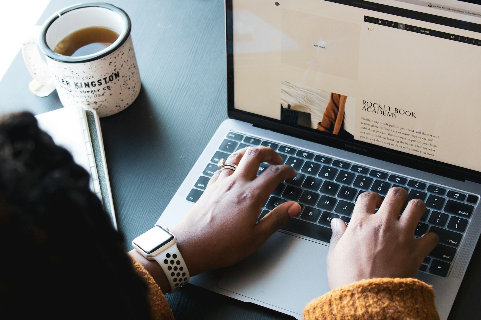 person using macbook pro on black table