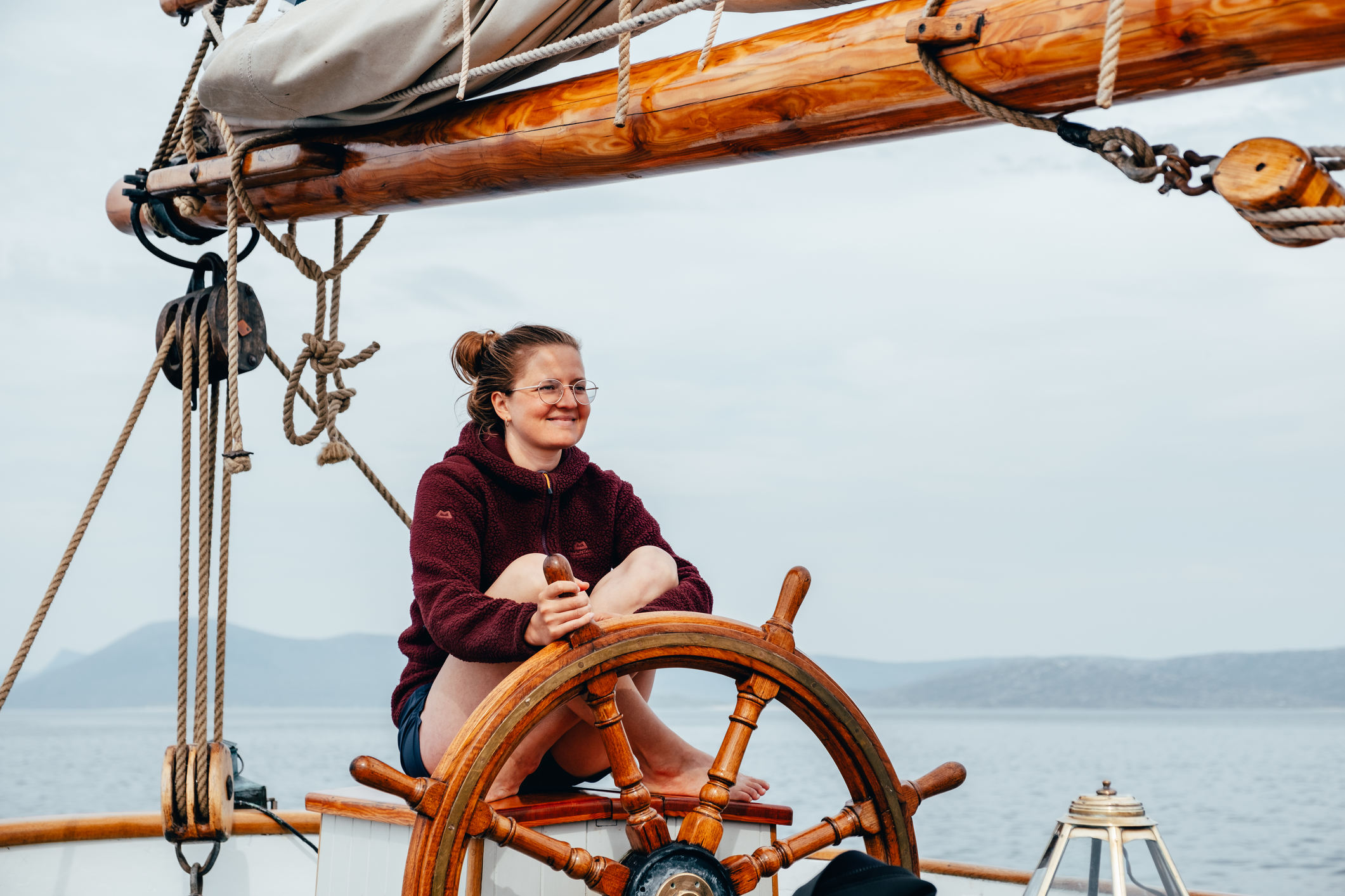 Woman at the helm on a tall ship sailing