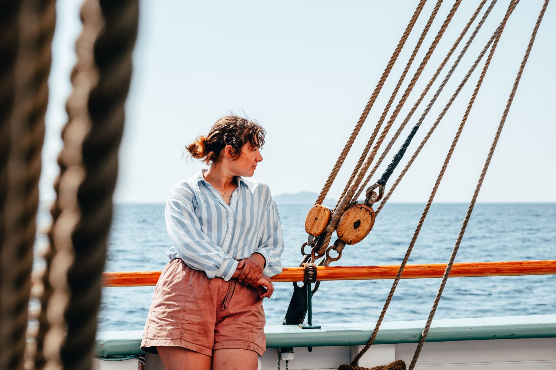 Woman looking out from a tall ship at sea