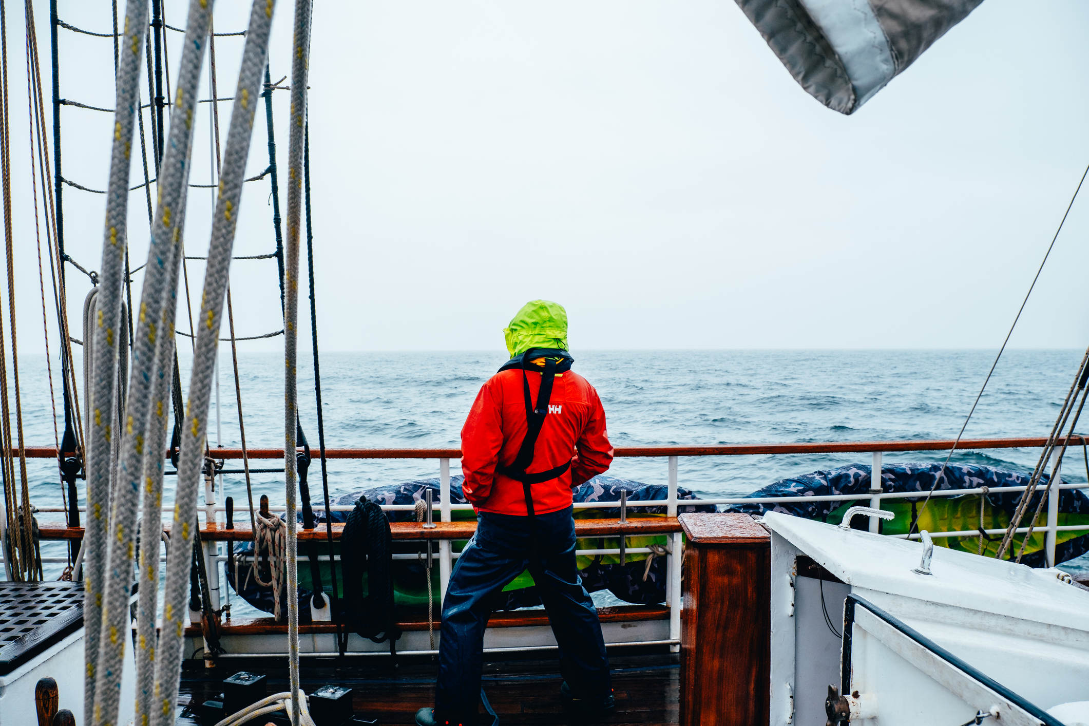 Man looking out from a tall ship in dramatic weather